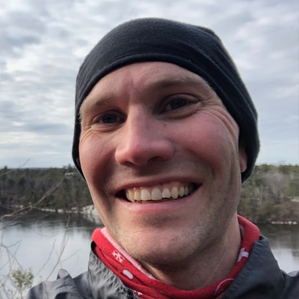 Sweaty man with glasses and red sweater in gym