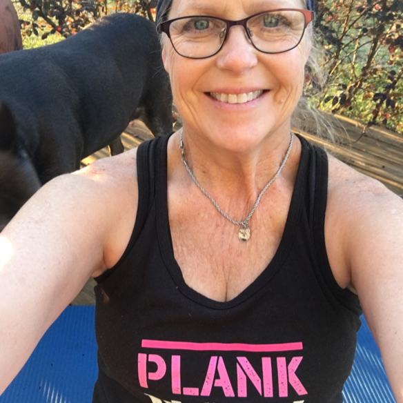 Half length shot of woman with glasses with dog in background